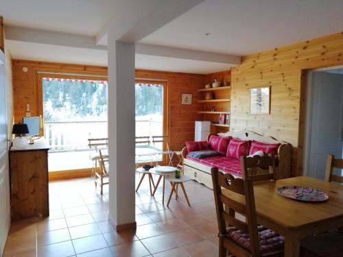 un salon avec un canapé rouge et une table dans l'établissement La Godille, à Pra-Loup