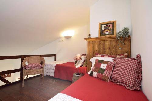 a bedroom with two beds and a chair in it at Case del Vicolo Stretto in Modica