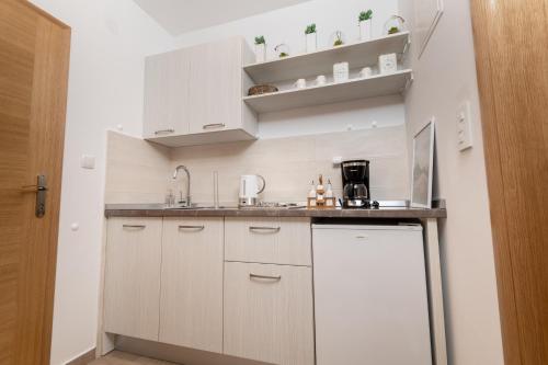 a small kitchen with white cabinets and a sink at Apartmani IVA in Neum