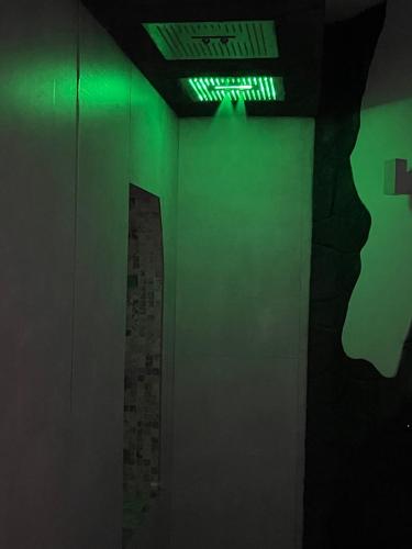 a dark room with green lights on a wall at Elite Apartment SPA in Catania