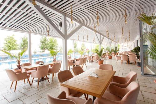 ママイア・ノルドにあるNautic Luxury Clubのテーブルと椅子のあるレストラン、プールを提供しています。