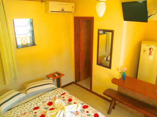 a bedroom with a bed and a table and a mirror at Pousada do Holandes Bahia in Barra Grande