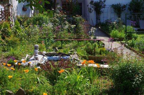 a garden with flowers and a bench in the middle at Maison Elizondoa - chambres, restaurant et SPA in Masparraute