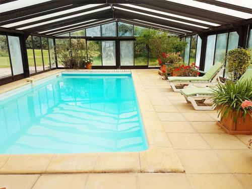 - une piscine dans une maison avec une véranda dans l'établissement Gîte de la Ferme Florale Ponoie, à Chezal-Benoît