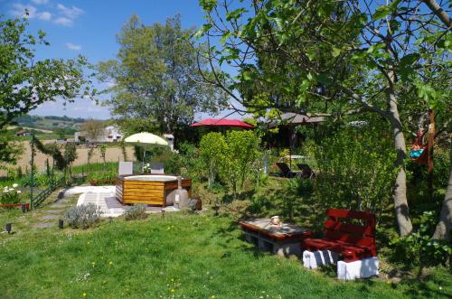 a garden with a bench and a table in the grass at Maison Elizondoa - chambres, restaurant et SPA in Masparraute