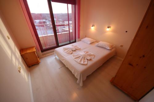 a bedroom with a large bed with towels on it at Menada Horyzont Apartments in Sozopol