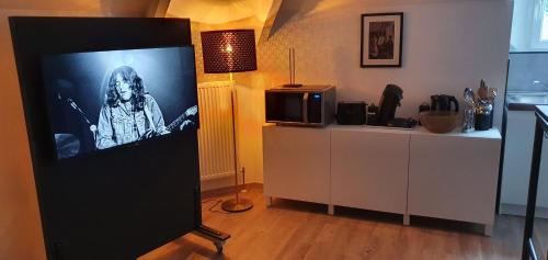 uma tela de TV com uma foto de um homem nela em Charmant studio avec grande baignoire em Namur