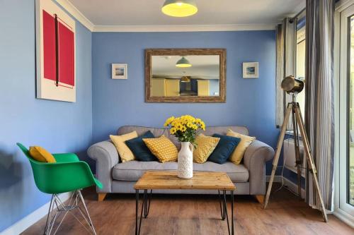 a living room with a couch and a mirror at Driftwood Cottage in Uny Lelant