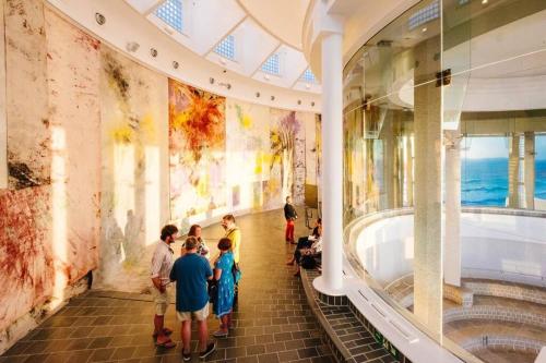 eine Gruppe von Menschen, die in einem Museum stehen und ein Gemälde ansehen in der Unterkunft Driftwood Cottage in Uny Lelant