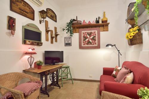 a living room with a couch and a table and a tv at Case del Vicolo Stretto in Modica