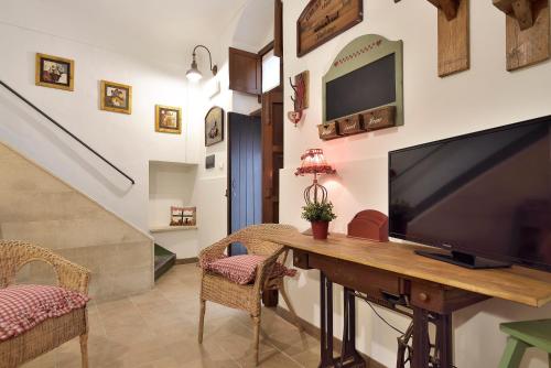 a living room with a large flat screen tv on a wooden table at Case del Vicolo Stretto in Modica