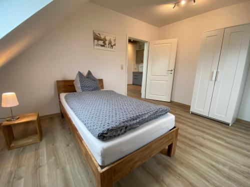 ein kleines Schlafzimmer mit einem Bett in einem Zimmer in der Unterkunft Etzel-Lodge Weideblick in Friedeburg