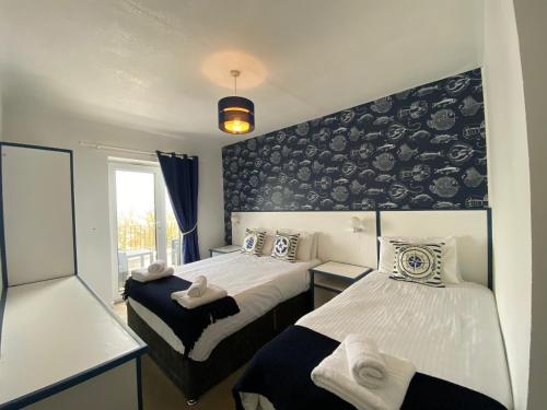 a bedroom with two beds and a black and white wall at The Harbour Bar & Bistro in Cemaes Bay