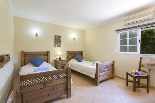a bedroom with two beds and a window at Villa Teotel by Villa Plus in Almancil