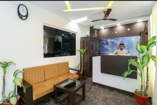 uma sala de estar com um sofá e uma televisão em Hotel ShivMurti Classic em Haridwar