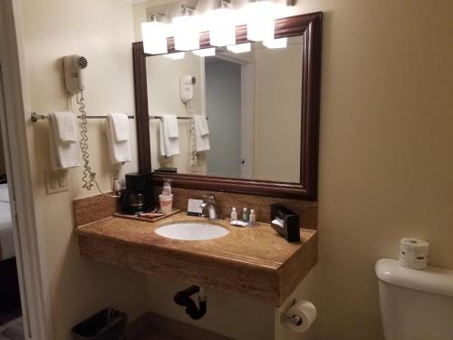 a bathroom with a sink and a mirror at Quality Inn Long Beach - Signal Hill in Long Beach