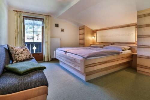 ein Schlafzimmer mit einem großen Bett und einem Sofa in der Unterkunft Haus Wiesenrand Kurz in Berchtesgaden