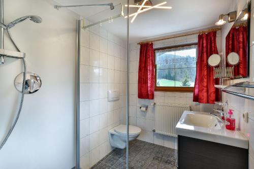 a bathroom with a shower and a toilet and a sink at Haus Wiesenrand Kurz in Berchtesgaden