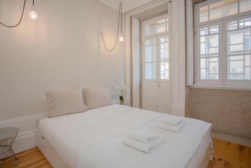 ポルトにあるLiiiving In Porto | Bolhão Market Apartmentsのベッドルーム1室(白いベッド1台、タオル2枚付)