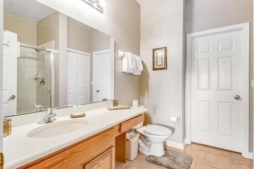 a bathroom with a sink and a toilet and a mirror at Oakwater Resort Cheshire Nook in Orlando