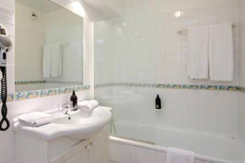 Un baño blanco con lavabo y ducha. en Monaco à 300m du Casino - Grand Studio avec Piscine, en Beausoleil