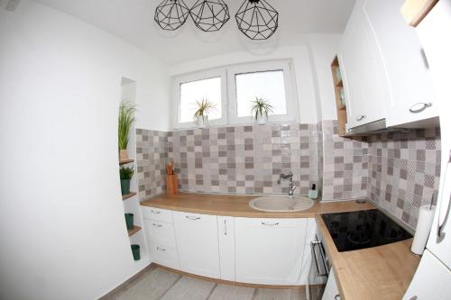 a kitchen with white cabinets and a sink at Apartman Lucija in Karlovac
