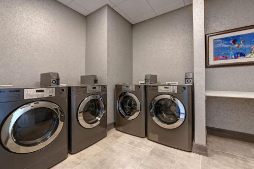 a laundry room with three washing machines in it at Homewood Suites By Hilton Austin/Cedar Park-Lakeline, Tx in Austin