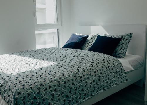 a bed with a black and white comforter and pillows at Villa Hodžić in Mostar