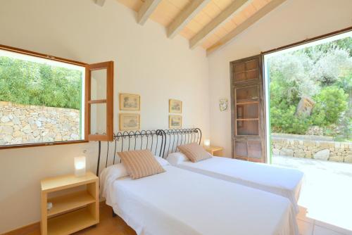 Una cama o camas en una habitación de Villa Son Llarg, Estallencs