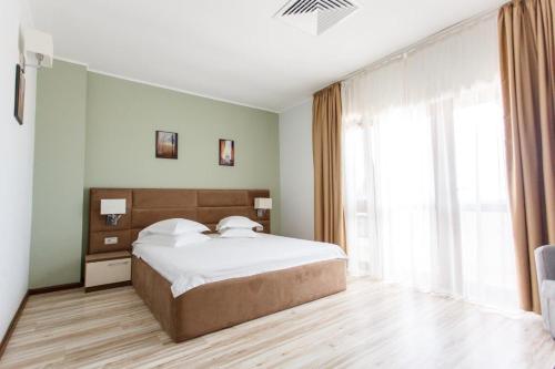a bedroom with a large bed and a large window at Nautic Sport Club in Mamaia Nord