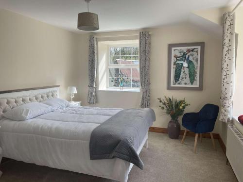 a bedroom with a large white bed and a window at Lacken Millhouse and Gardens in Cavan