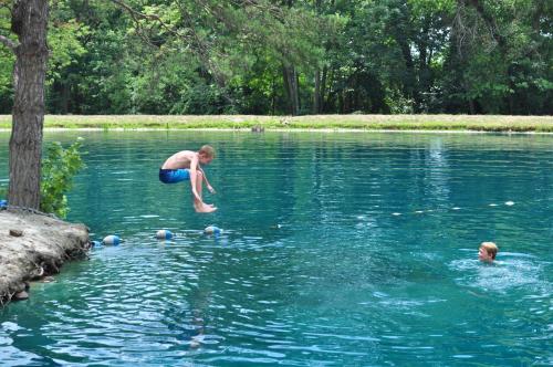 a man jumping into a lake with other people in the water at Spring Gulch Chalet 12 in Mount Airy