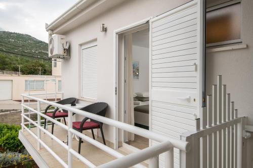 a balcony with two chairs and a table at Apartmani IVA in Neum