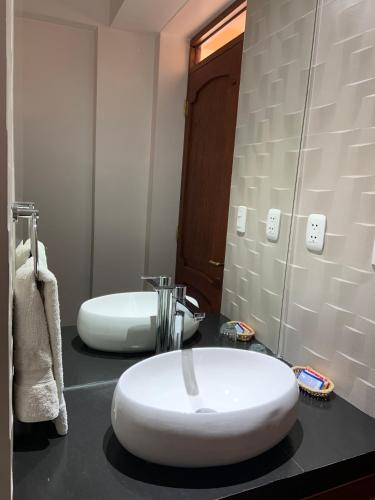 a bathroom with two white sinks on a counter at Amerindia in Cusco