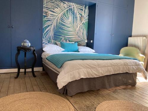 a bedroom with a bed with a blue wall at La Maison de Jeanne in Dieppe