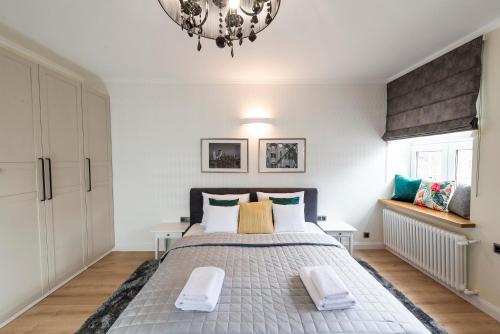 a bedroom with a large bed and a chandelier at Right Stay Studio in Gdańsk