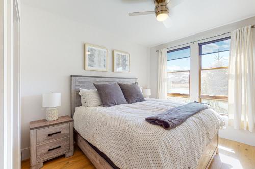 a white bedroom with a bed and a window at Blue River Flats Condos in Silverthorne