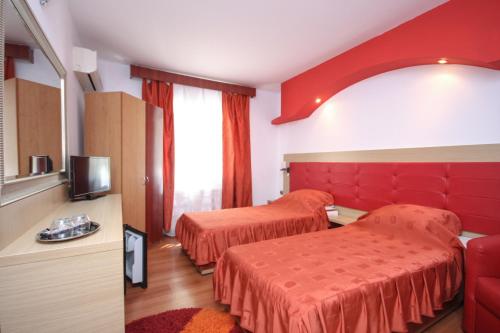 a hotel room with two beds and a tv at Casa Coral Sulina in Sulina