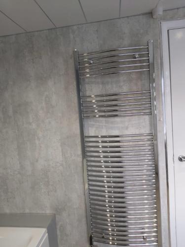 a metal shutter on a wall in a bathroom at Amble Holiday Home in Amble