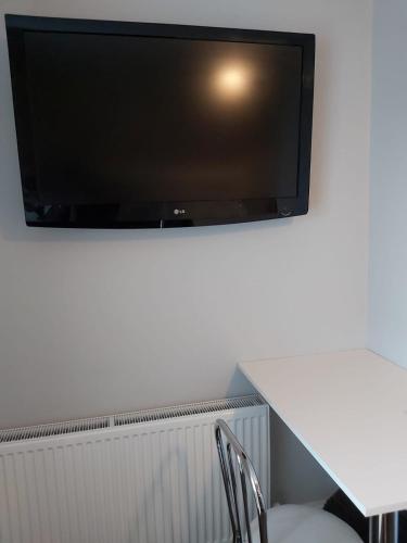 a flat screen tv hanging on a wall at Amble Holiday Home in Amble