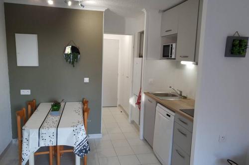 une petite cuisine avec une table, des chaises et un évier dans l'établissement Les Parcs de Grimaud, à Grimaud