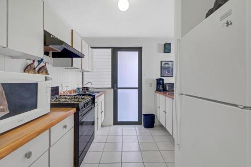 a kitchen with white cabinets and a stove top oven at MS Exclusiva Suite Alberca Bernardo Quintana 12B in Mendiola