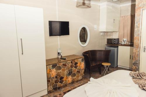 Habitación de hotel con cama y cocina en APICAL GUESTHOUSE en Maun