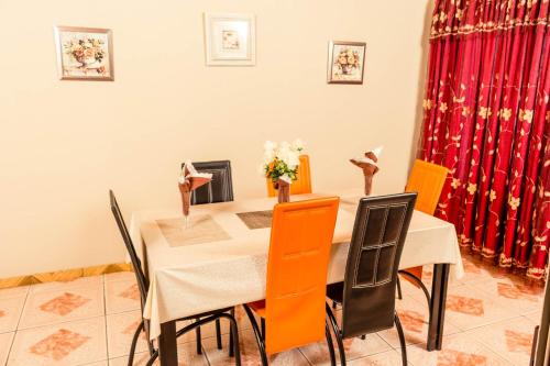 a dining room with a table and orange chairs at APICAL GUESTHOUSE in Maun
