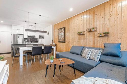 a living room with a blue couch and a table at The Hut by BnbCopilote in Quebec City