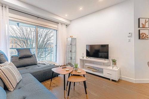 a living room with a couch and a tv at The Hut by BnbCopilote in Quebec City