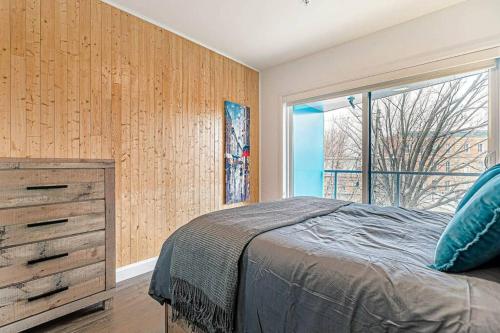 a bedroom with a bed and a dresser and a window at The Hut by BnbCopilote in Quebec City