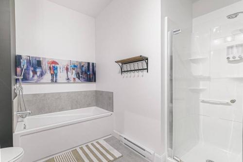 a white bathroom with a shower and a toilet at The Hut by BnbCopilote in Quebec City