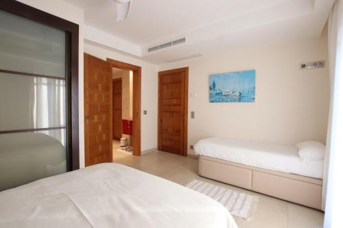 Un dormitorio blanco con dos camas y una ventana. en Casa Quermansó, en Vilajuïga