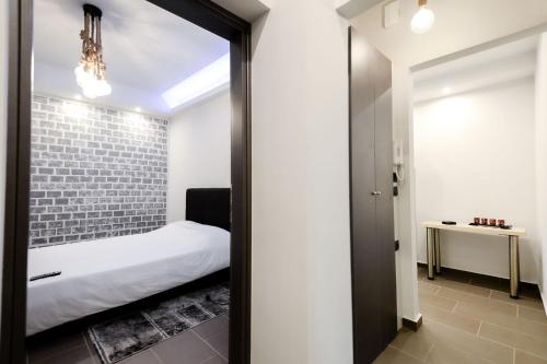 a bedroom with a bed and a brick wall at CENTRO PATRAS in Patra